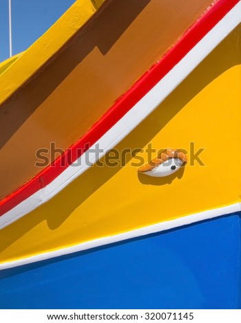MARSAXLOKK, MALTA - SEPTEMBER 15, 2015: Colorful painted wood boat with the typical protective eye on a sunny day in September 15, 2015 in Marsaxlokk, Malta.