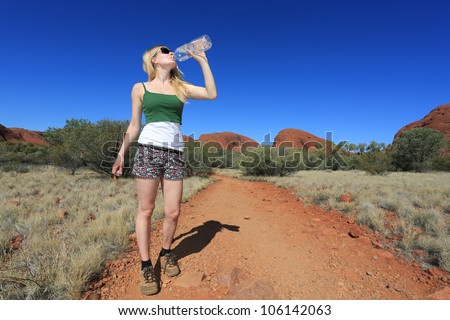 Woman drinking water in australian outback, Northern Territory