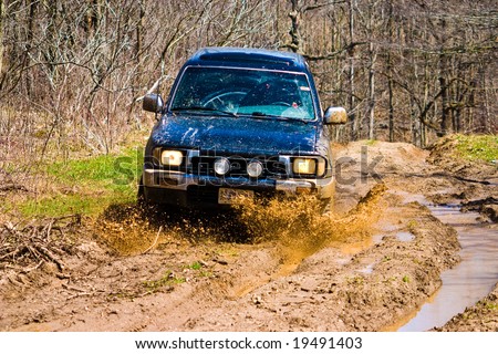 Off-road car going through deep mud holes