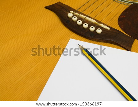 Pencil and paper on the guitar.