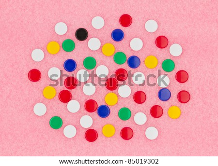 Colorful of thumb tack on pink board.