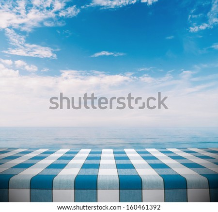 Blue tablecloth on calm ocean with cloudy sky