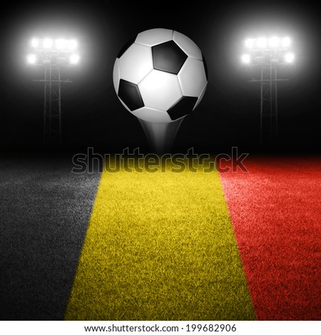 Soccer ball in mid air above belgian flag field with illuminated stadium lights in background