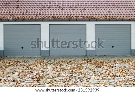 Three garage doors during fall season