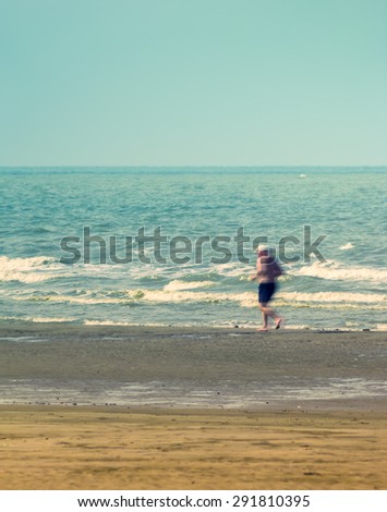 Old man running on beach, motion blur