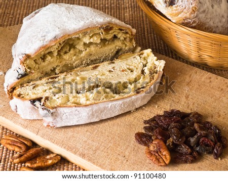Christmas bread with raisins and nuts on wooden board