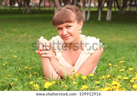 beautiful young woman lying on the grass in the park, good emotions