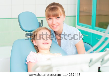 mother and daughter visit the dentist, the child is sitting in the dental chair and mother near