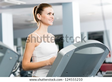 woman runs on a treadmill in the fitness club