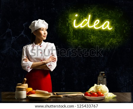 Asian female chef looking at the glowing title idea, place for text