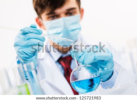 scientist working in the lab examines a test tube with liquid