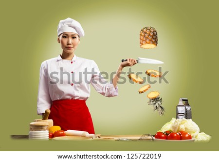 Asian female chef cuts pineapple, creative cuisine
