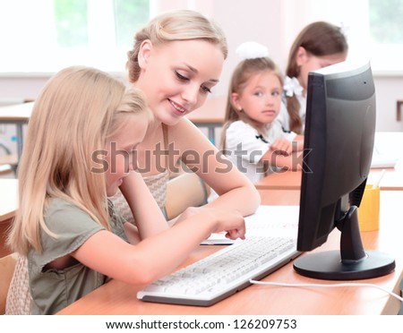 teacher explains the task schoolgirl at the computer the new technologies in education teacher explains the task schoolgirl at the computer the new technologies in education