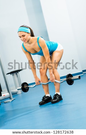 young woman doing body-building in the Gym, live a healthy life