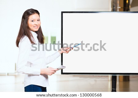 attractive young Asian woman, points to an empty display, place for text
