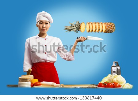 Asian female chef cuts pineapple, creative cuisine