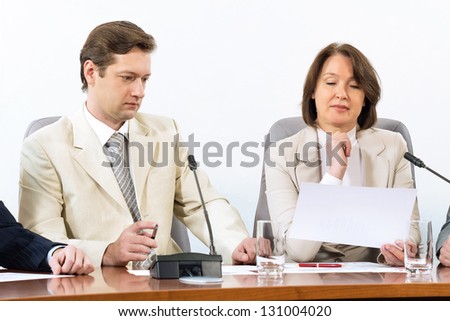 Senior business woman working with documents at the conference, on the table microphone stand