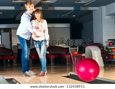 guy hugs her friendgirl, playing together in bowling