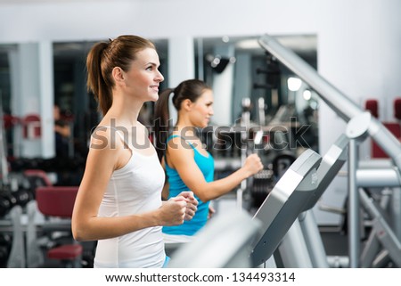 women running on a treadmill in a fitness club, sport in the fitness club