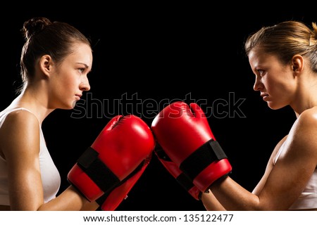 two female boxers face each other, pushing the boxing gloves, start a fight