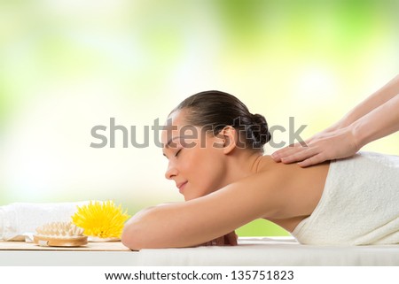 beautiful spa woman lying on the couch, in front of her flower and rolled towel