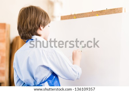 portrait of a boy standing next to his easel, a drawing lesson