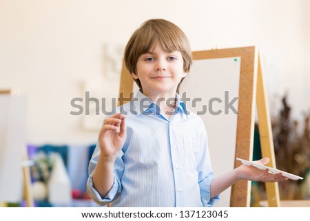 portrait of a boy standing next to his easel, a drawing lesson