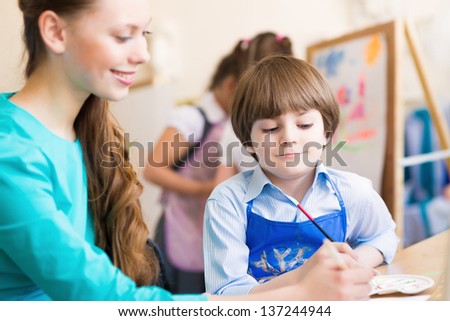teacher deals with a boy, a drawing lesson
