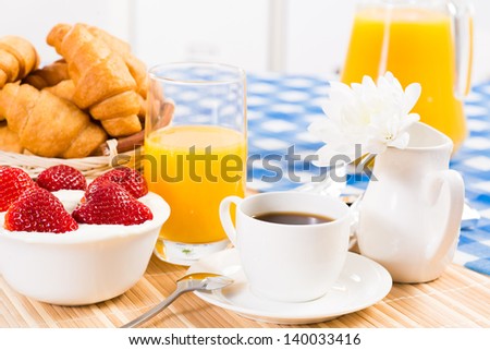 continental breakfast: coffee, strawberry and cream, croissant and juice