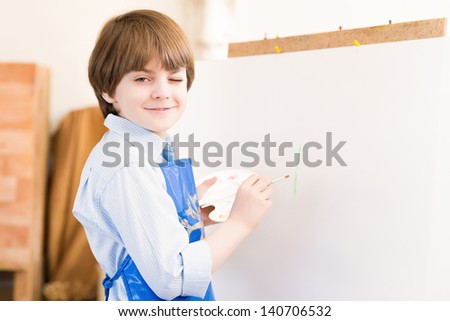 portrait of a boy standing next to his easel, a drawing lesson