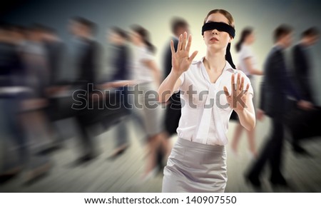 young blindfolded woman. seeking a way out in a crowd