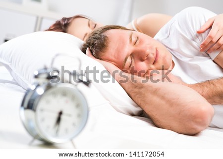 Mature man sleeping in bed with his wife