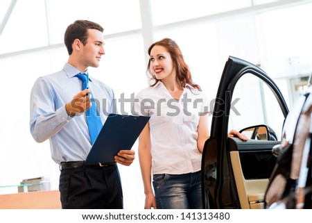 car salesman declares a young girl advantages of the new car