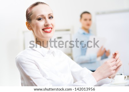 portrait of a business woman in office, smiling and looking into the camera, office work