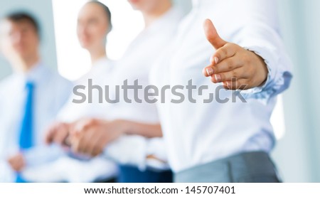 invitation to the team, business woman holds out her hand, her face a number of young businessmen