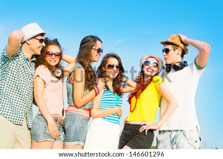 group of young people wearing sunglasses and hats hugging and standing in a row, spending time with friends