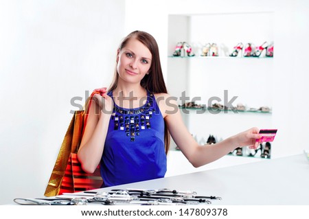 Young woman at shopping mall checkout counter paying through credit card