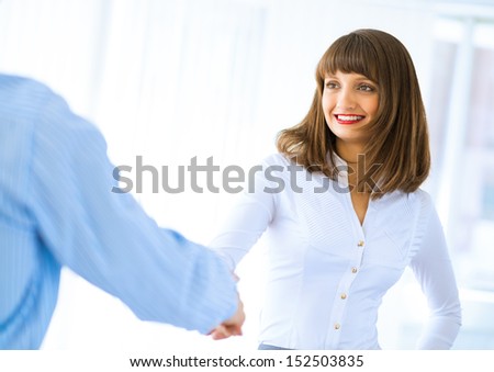 Business woman shaking hands and smiling colleague