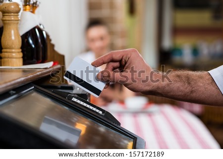 Waiter Inserts The Card Into A Computer Terminal, Against Visiting The Restaurant