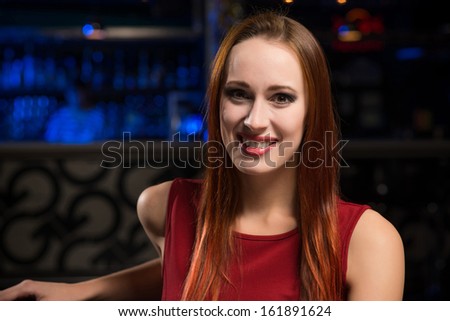 portrait of a woman in a nightclub, sitting on the couch and talking with man