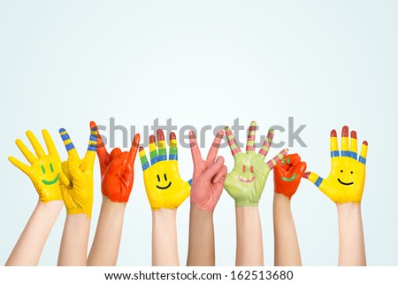 painted children\'s hands in different colors with smilies