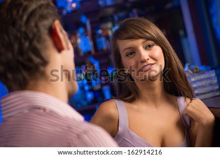 portrait of a nice woman at the bar, talking with a man at the bar date