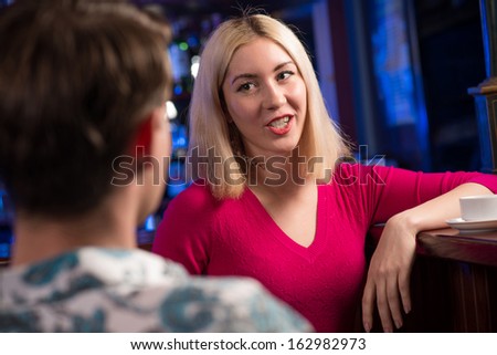 portrait of a nice woman at the bar, talking with a man at the bar date