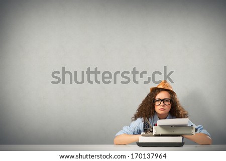 image of a young woman writer at the table with typewriter