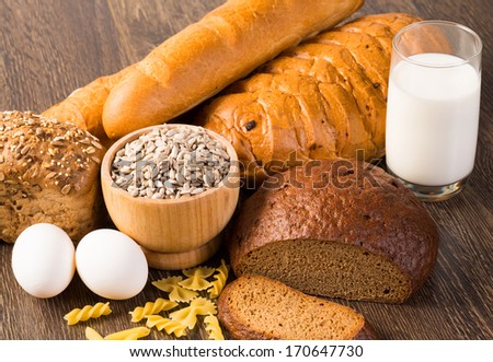 Fresh bread, eggs, pasta, glass of milk and grains. cook fresh bread at home