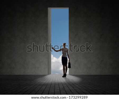 business woman standing near a hole in the wall of the hole at her light falls