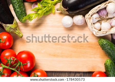 tomatoes, cucumber, garlic, fresh herbs on chopping board