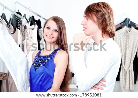 cute man and the woman in shop choose clothes