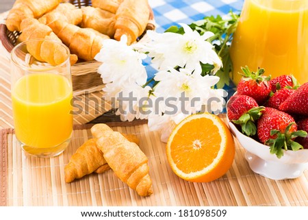 orange juice, croissants and strawberries still life