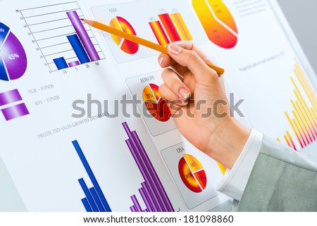 female hand pointing pencil on financial charts, paper work in the office